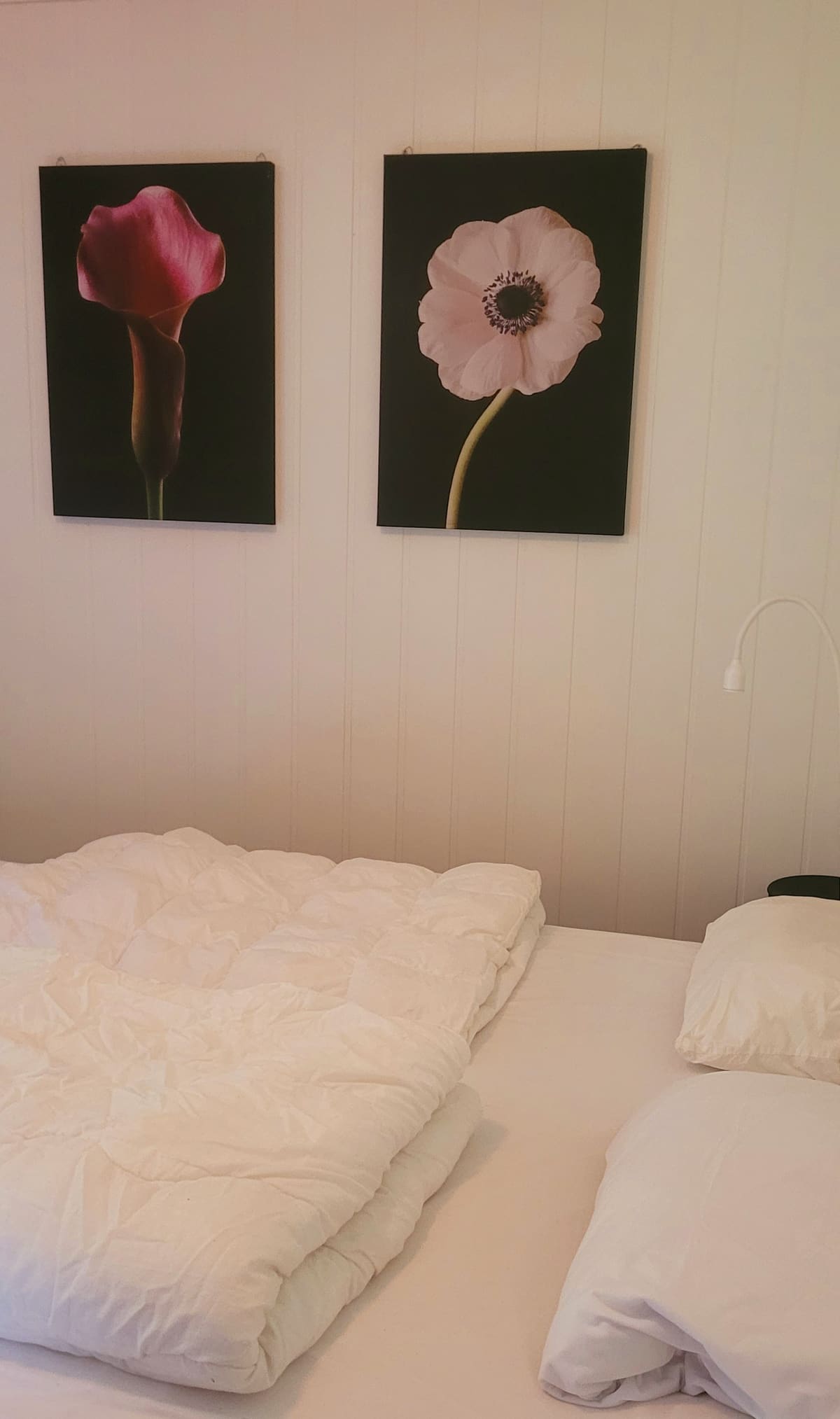 Soverom i Hytte 1 med dobbeltseng, dyner og bilete på veggen