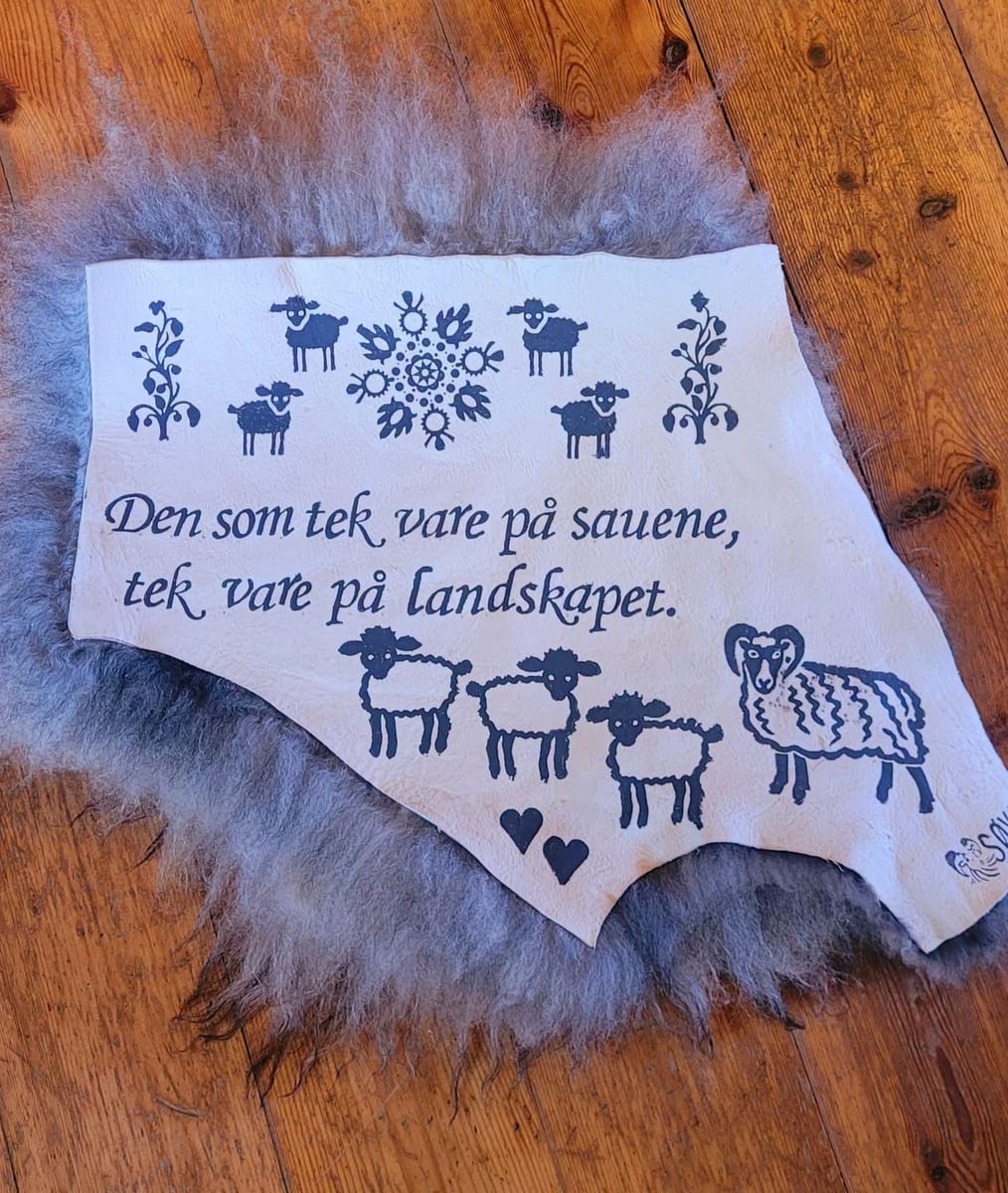 Saueskinn med trykket «Den som tek vare på sauene, tek vare på landskapet»